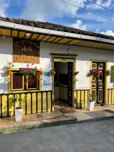 a restaurant with a yellow and white building at La Posada de La Abuela Salento in Salento
