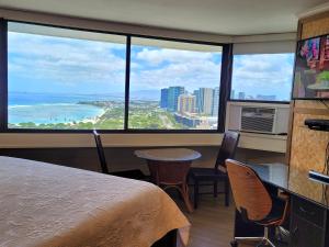 a room with a bed and a table and chairs at Spacious Studio w/ Parking, beach/mall/park in Honolulu
