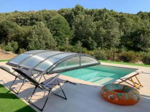 a swimming pool with a table and an umbrella at Quinta do Borges 2 in Guarda