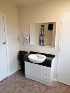 a bathroom with a sink and a mirror at Stanley Apartments in Hamilton