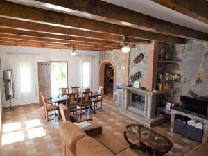 a living room with a fireplace and a table and chairs at Belvilla by OYO Villa Mariposa in Arenas