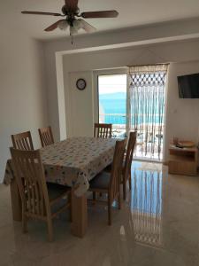 ein Esszimmer mit Tisch und Stühlen und einem Fenster in der Unterkunft Apartments by the sea Podgora, Makarska - 11469 in Podgora