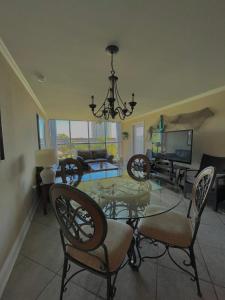 a dining room with a glass table and chairs at Biloxi Beach Condo in Biloxi