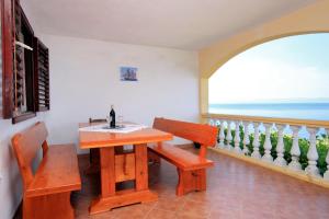 comedor con mesa, banco y ventana en Apartments by the sea Prigradica, Korcula - 543, en Blato