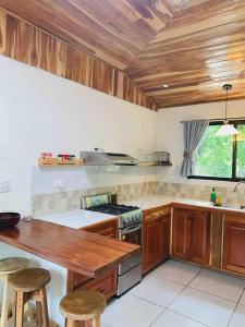 uma cozinha com armários de madeira e um forno com placa de fogão em Beautiful 2-bedroom home OR Studio Apartment OPTION in Santa Cruz em Santa Cruz