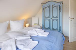 a blue and white bed with white towels on it at Captains Home in List