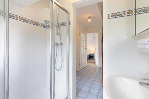a bathroom with a shower and a sink at Captains Home in List +26 photos