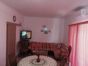 ein Wohnzimmer mit einem Sofa und einem Tisch in der Unterkunft Apartments by the sea Cove Ostricka luka, Rogoznica - 13709 in Rogoznica