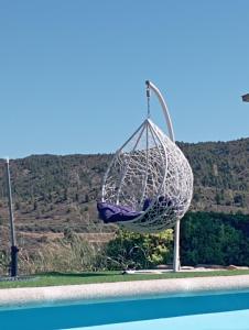 a hammock hanging next to a pool with a mountain at Cabezo Buñuel Hostal in Calanda