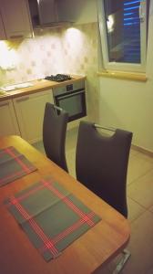 cocina con mesa de madera y 2 sillas en Apartments by the sea Ugljan - 15104 en Ugljan