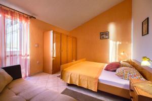 - une chambre avec un lit et un canapé dans l'établissement Apartments for families with children Kampor, Rab - 15144, à Rab