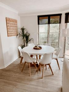 a white dining room with a white table and chairs at Sea Breeze on Main Beach in Byron Bay