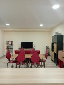 a room with red chairs and tables in a room at Cabezo Buñuel alojamiento Rural in Calanda
