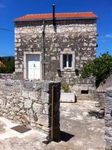 a stone building with two windows and a red roof at Holiday house with a parking space Lumbarda, Korcula - 15165 in Lumbarda