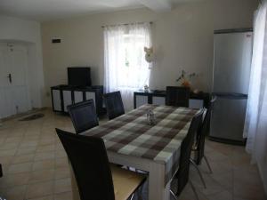 a kitchen with a table with chairs and a refrigerator at Holiday house with a parking space Lumbarda, Korcula - 15165 in Lumbarda