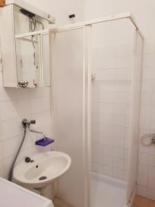 a white bathroom with a sink and a shower at Apartments by the sea Cove Koromasna, Zirje - 15166 in Žirje