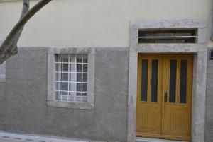 a building with a wooden door and a window at Apartments by the sea Cres - 15171 in Cres