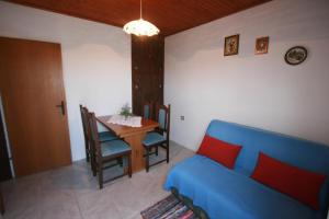 uma sala de estar com um sofá azul e uma mesa em Apartments with a parking space Valbandon, Fazana - 15161 em Fažana