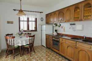 a kitchen with a table with chairs and a refrigerator at Apartments with parking space Splitska, Brac - 15197 in Splitska