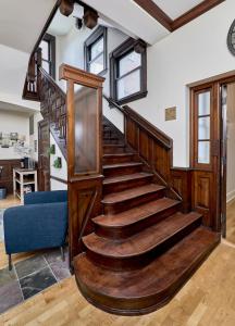 a wooden spiral staircase in a living room at White House at Grand Central in Tower Grove