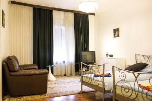 een woonkamer met een bank, een stoel en een televisie bij Twin Room Zagreb 15219a in Zagreb