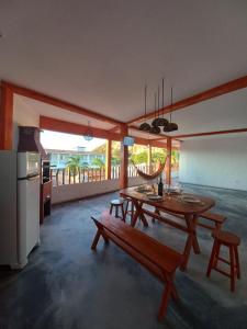 a living room with a wooden table and a kitchen at Recanto pais e filho in Monte das Gameleiras