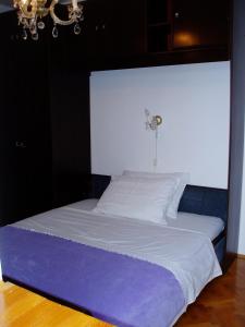 Dobrinj的住宿－Apartments with a parking space Tribulje, Krk - 15223，一张带白色床单和紫色床单的床