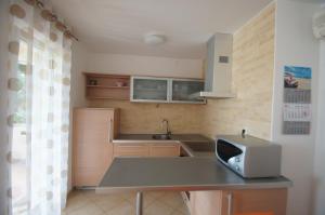 a small kitchen with a table and a microwave at Apartments with a parking space Punat, Krk - 15231 in Punat