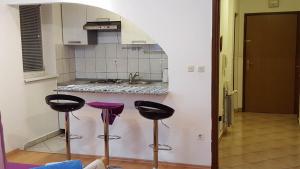 een keuken met drie barkrukken voor een aanrecht bij Apartments with a parking space Senj - 15236 in Senj