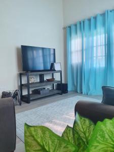 a living room with a flat screen tv and blue curtains at Quiet Country Living in Saint George