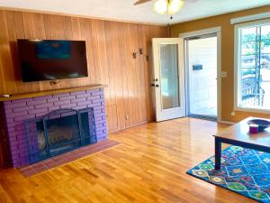 uma sala de estar com lareira e uma televisão por cima em Welcome! Colorful 50's Ranch in the Heart of Eugene em Eugene