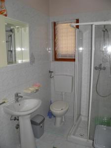 a bathroom with a shower and a toilet and a sink at Apartments by the sea Sveti Ivan, Umag - 9692 in Umag