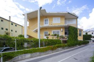 a yellow house with a balcony on a street at Studio Podgora 12816c in Podgora
