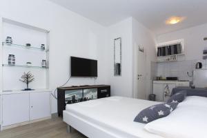 a bedroom with two beds and a flat screen tv at Studio Podgora 12816c in Podgora