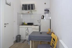 a small kitchen with a table and a refrigerator at Studio Podgora 12816c in Podgora