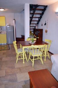 Veprinac的住宿－Family friendly apartments with a swimming pool Veprinac, Opatija - 14916，厨房里设有黄色的餐桌和椅子