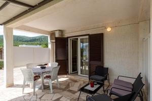 a patio with a table and chairs on a patio at Apartments by the sea Kneza, Korcula - 10168 in Račišće