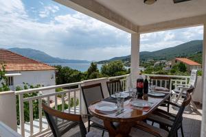 a table on a balcony with a view of the water at Apartments by the sea Kneza, Korcula - 10168 in Račišće