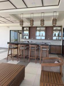 a kitchen with a bar with wooden stools at Calathea Place by DMCI in Paranaque in Manila