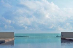 a view of the ocean from a swimming pool at 3BRs Apartment w/ Infinity Pool Near KTCC & Beach in Kuala Terengganu