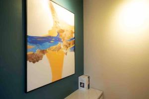 a painting on a wall above a toilet in a room at 3BRs Apartment w/ Infinity Pool Near KTCC & Beach in Kuala Terengganu