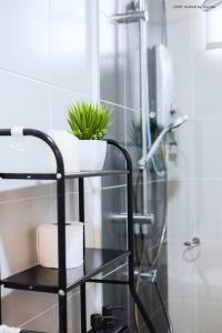 a bathroom with a shower with a plant on a shelf at 3BRs Apartment w/ Infinity Pool Near KTCC & Beach in Kuala Terengganu