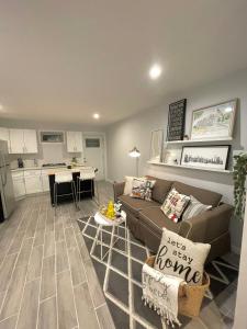 uma sala de estar com um sofá e uma cozinha em Modern apartment with parking & quick ride to Manhattan em Cedar Manor