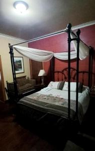 ルハン・デ・クージョにあるQuinta Ugarteのベッドルーム(天蓋付きベッド1台、ソファ付)
