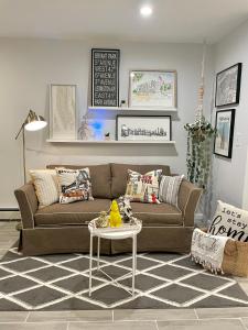 sala de estar con sofá marrón y mesa en Modern apartment with parking & quick ride to Manhattan en Cedar Manor