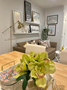una sala de estar con una mesa con un jarrón de flores en Modern apartment with parking & quick ride to Manhattan, en Cedar Manor