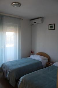 a hotel room with two beds and a window at Apartments and rooms with parking space Trilj, Zagora - 14609 in Trilj