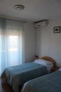 a bedroom with two beds and a window at Apartments and rooms with parking space Trilj, Zagora - 14609 in Trilj