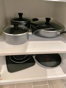 two pots and pans sitting on a shelf at Modern apartment with parking & quick ride to Manhattan in Cedar Manor