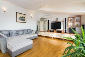 uma sala de estar com um sofá e uma televisão de ecrã plano em Apartments with a swimming pool Kastel Kambelovac, Kastela - 12073 em Kaštela